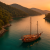 Traditional wooden gulet anchored in turquoise bay near Göcek at sunset with guests dining on deck